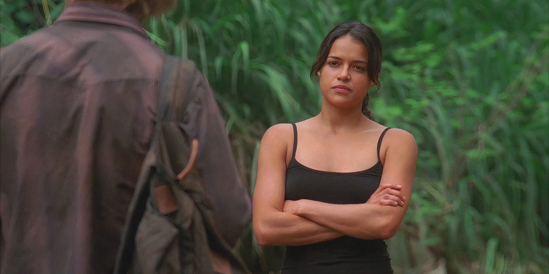 Ana Lucia (played by Michelle Rodriguez), confronts Sawyer (Josh Holloway) in the jungle with her arms crossed in Lost’s Season 2 Episode ‘Two for the Road.’