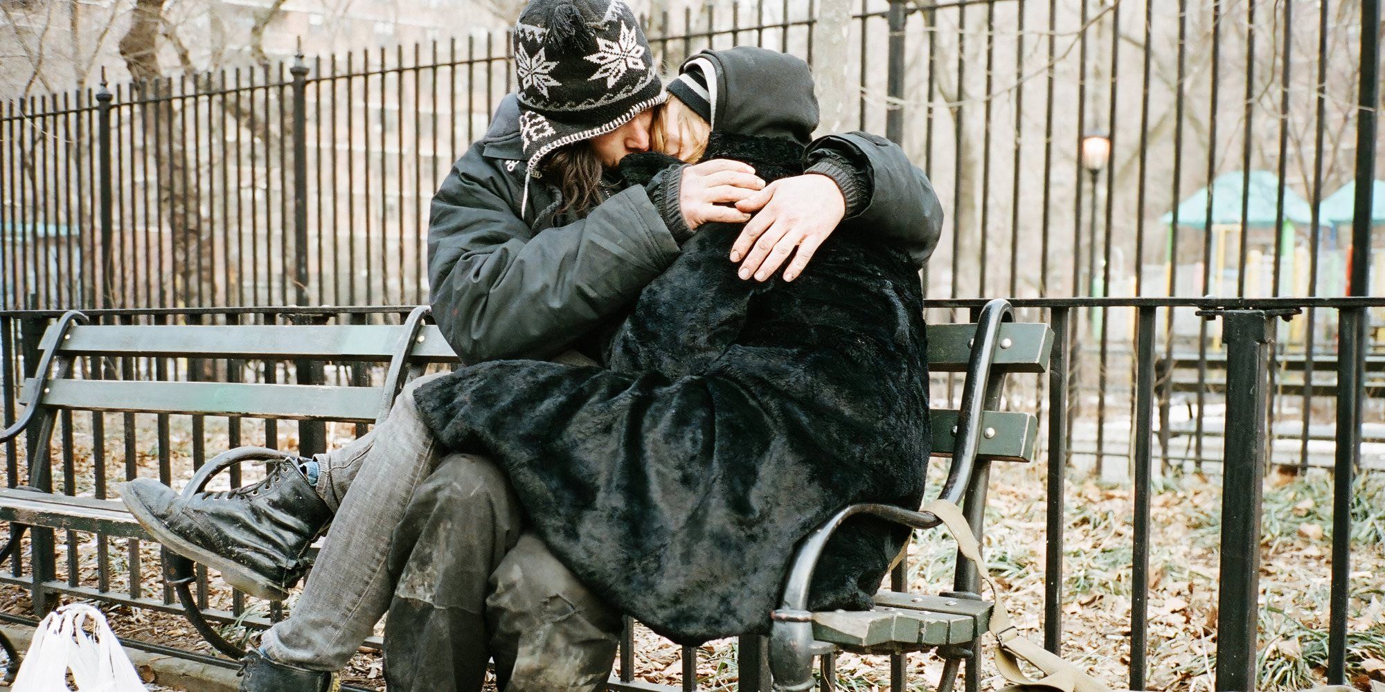 Arielle Holmes as Harley and Buddy Duress as Mike in Heaven Knows What cuddling while seated on a bench.