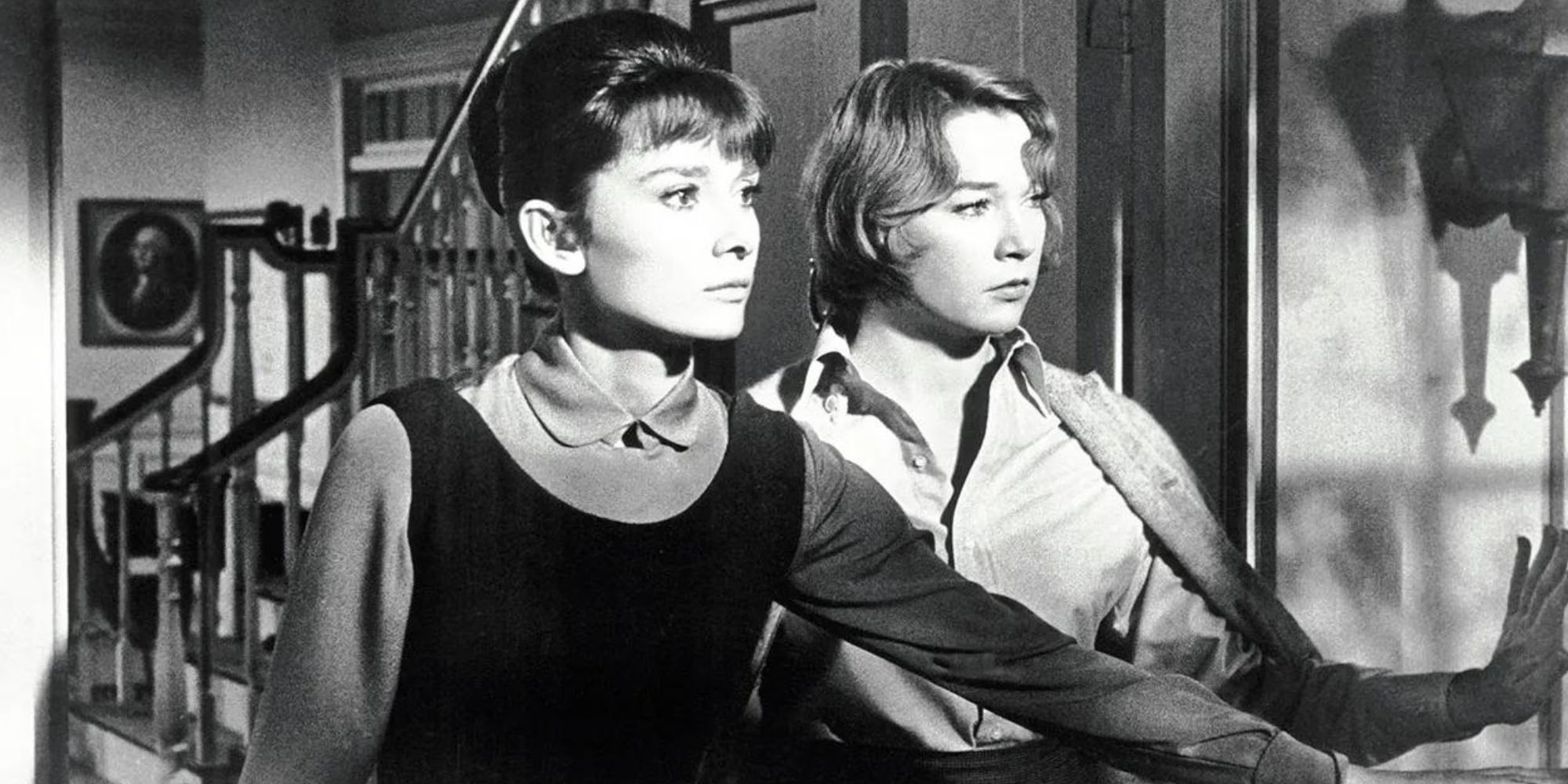 Audrey Hepburn standing with Shirley MacLaine in an open doorway looking out in The Children&rsquo;s Hour (1961)