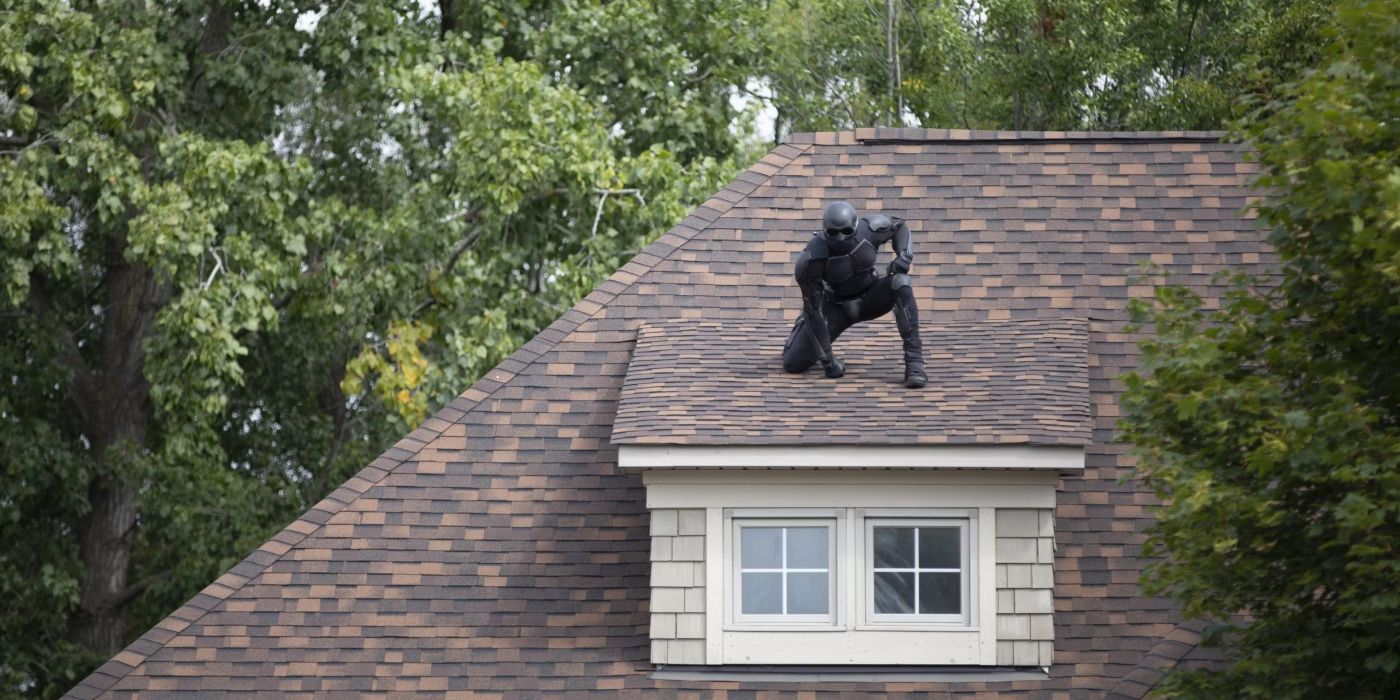 Superhéroe negro negro posa en el techo de una residencia en la temporada 1 de The Boys