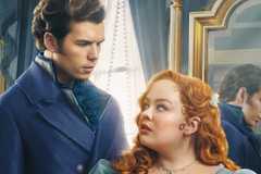 Colin and Penelope stand in front of a mirror while gazing into each other's eyes in a poster for Bridgerton Season 3