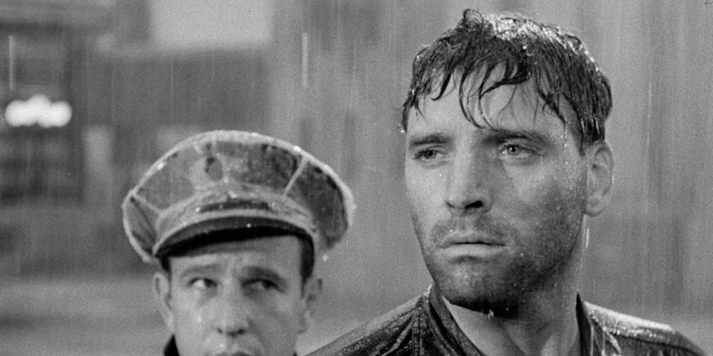 Joe Collins under the rain looking serious in Brute Force