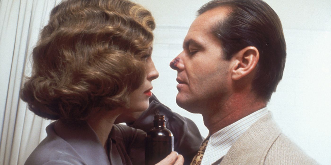 Faye Dunaway holding up a glass bottle between her and Jack Nicholson