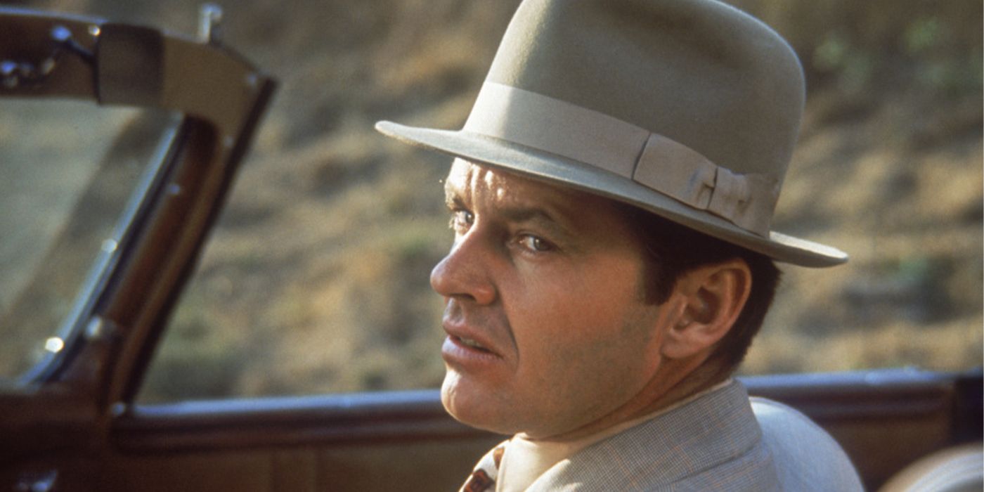 Jack Nicholson looking over his shoulder with a scowl in a car in Chinatown