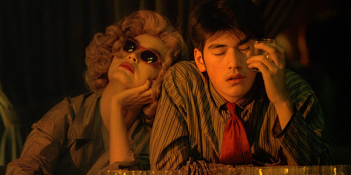 The Woman in the Blonde Wig (Brigitte Lin) lays on the shoulder of Ah Wu (Takeshi Kaneshiro) as he rests his head in his hand while leaning his elbow on a desk