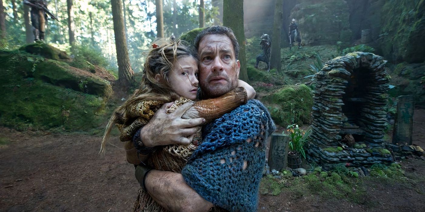 Tom Hanks (right) embraces a young girl (right) as armed men surround them in the forest