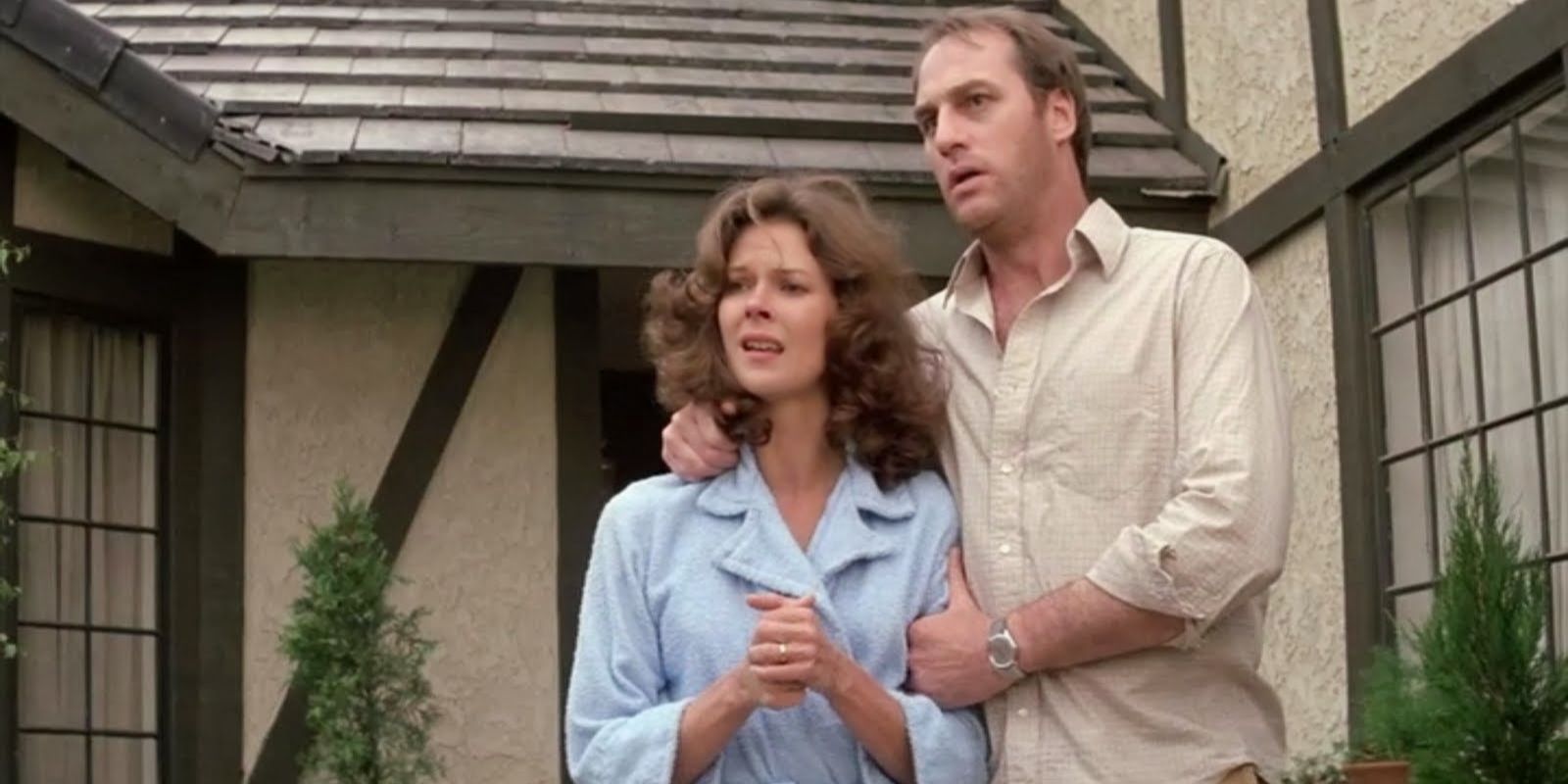 A couple look concerned on their front porch in the horror movie 'Poltergeist'.