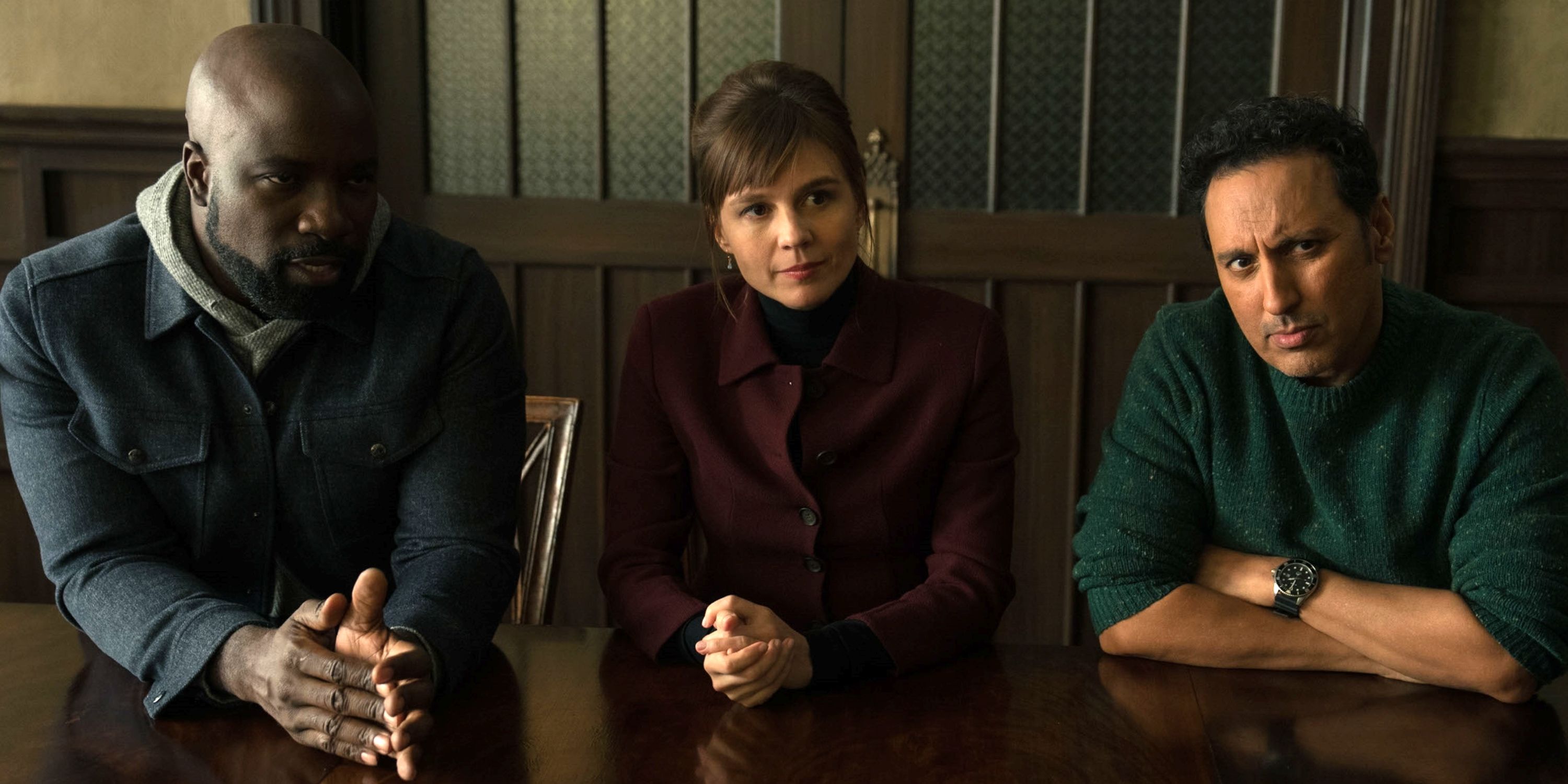 Katja Herbers as Kristen sitting at a table between Mike Colter as David & Aasif Mandiv as Ben in Evil