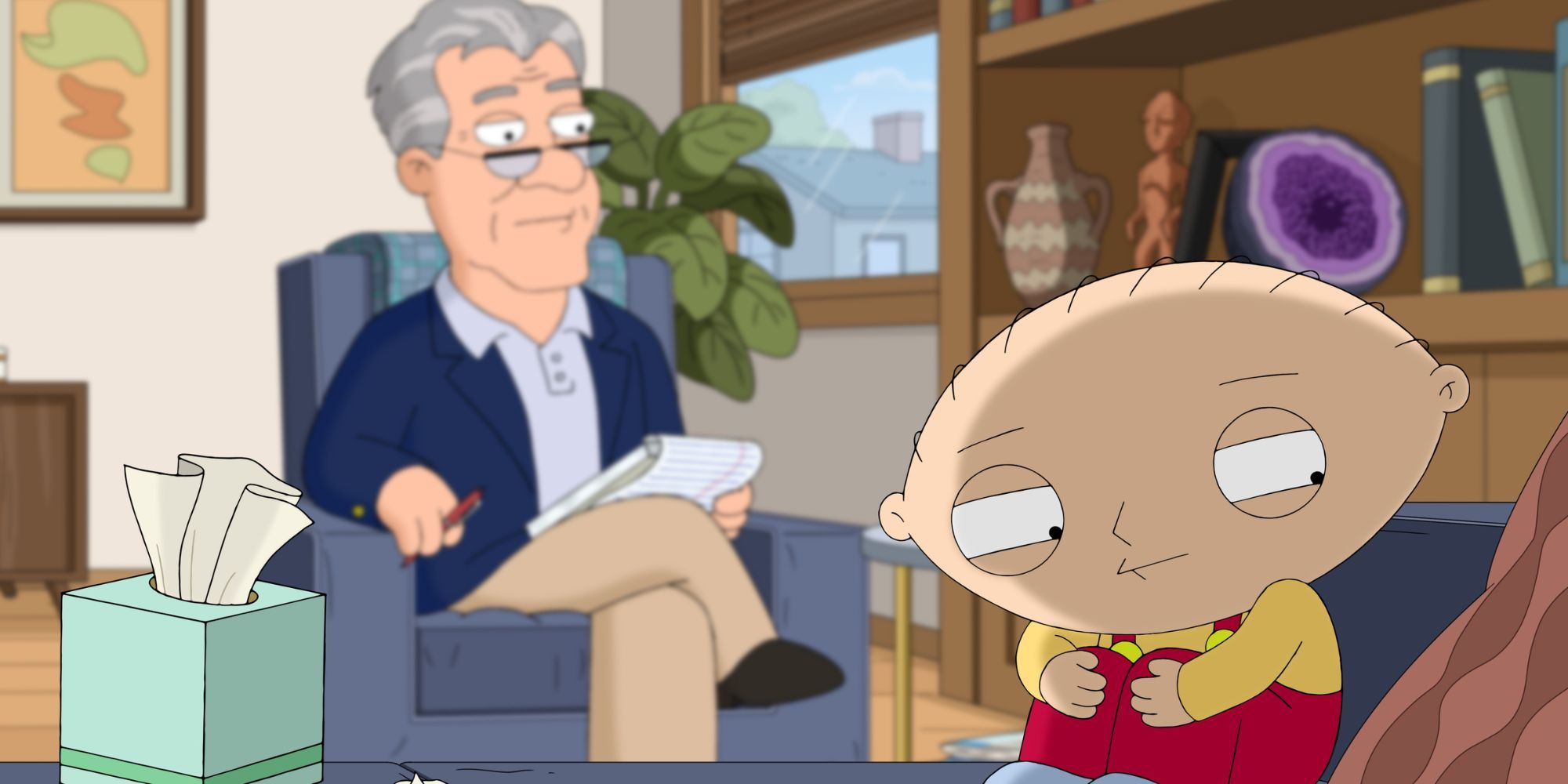 Stewie Griffin sitting on a couch with his legs to his chest while a man in a chair with a notebook and pen is sitting across from him in Family Guy