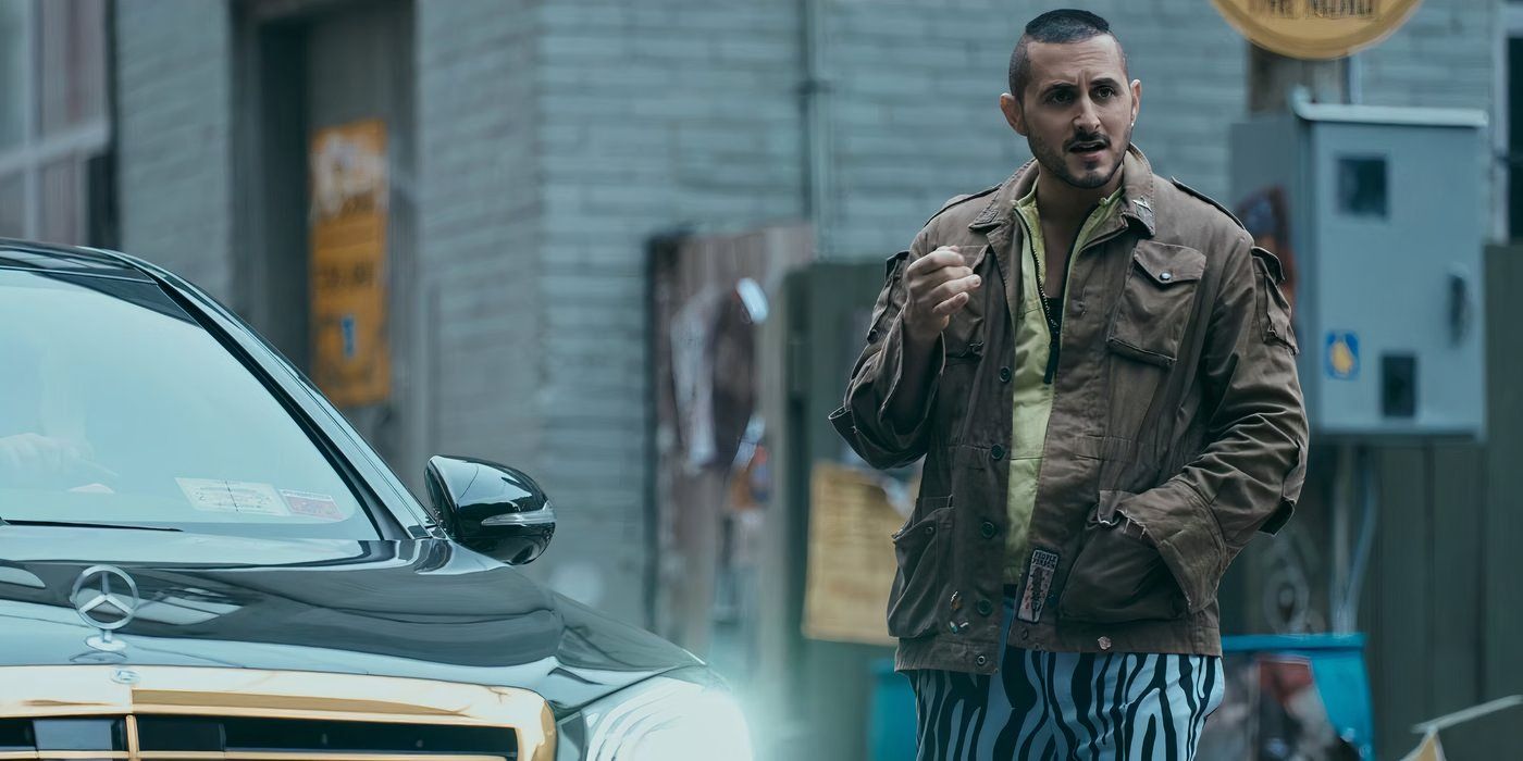 Tomer Capone as Frenchie in 'The Boys' wearing striped pants in front of a car