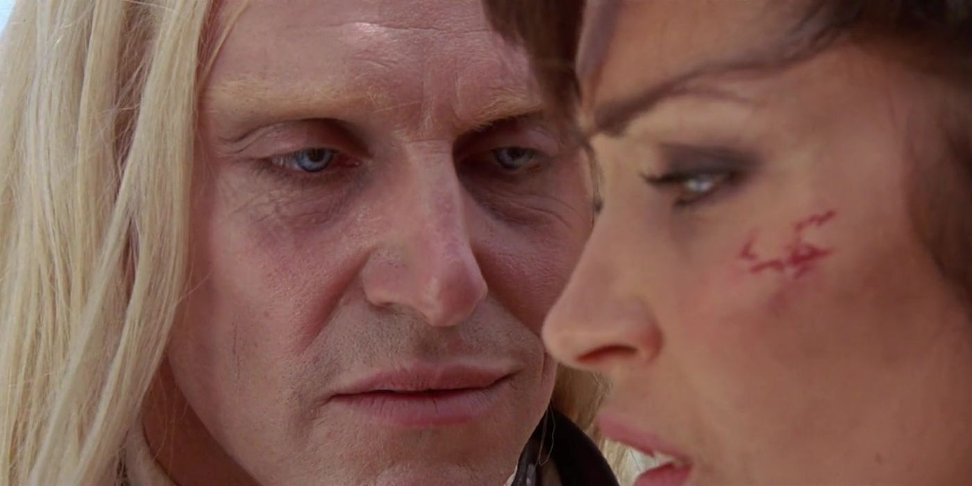 A man smirking while approaching a woman in Gallowwalkers