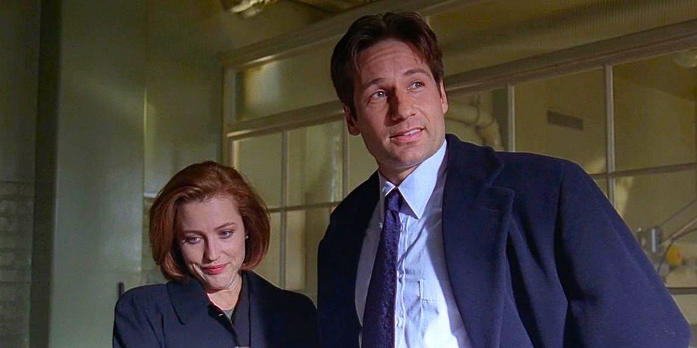 Gillian Anderson and David Duchovny grin sheepishly standing next to each other in The X-Files