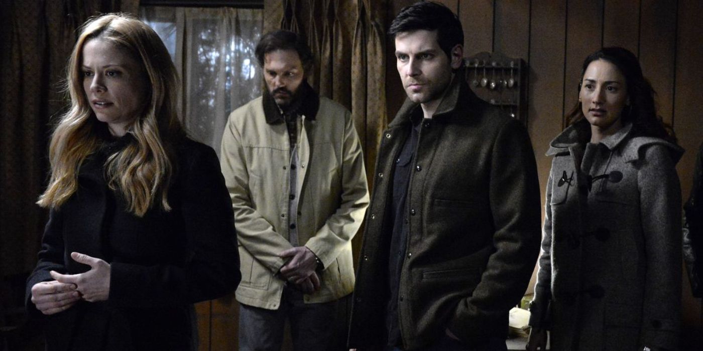 Adalind (Claire Coffee) stands with her back turned to Nick Burkhardt (David Giuntoli) and his friends as they stand in a wooden cabin in 'Grimm' Season 6, Episode 13 "The End" (2017).
