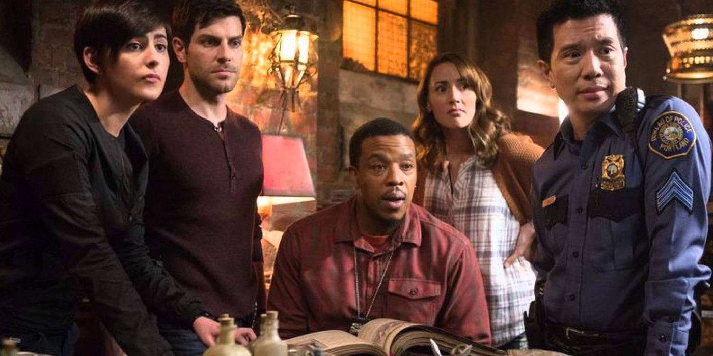 Nick Burkhardt (David Giuntoli) and his allies stand around Hank Griffin (Russell Hornsby) as he reads through a book, though they all look at something off screen in 'Grimm' Season 5, Episode 10 "Map of the Seven Knights" (2016).