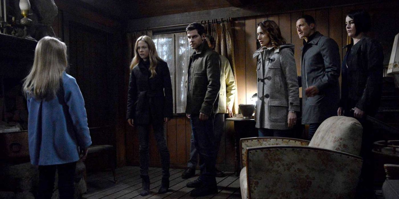 Nick Burkhardt and his allies stand around in a small wooden room facing young Diana who stands before them in a blue coat in 'Grimm' Season 6, Episode 12 "Zestörer Shrugged" (2017).
