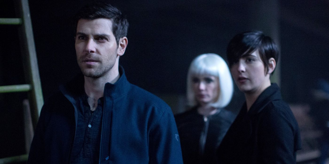 Nick Burkhardt (David Giuntoli) stands glaring at someone in a dark room while Trubel (Jacqueline Toboni) and Eve (Bitsie Tulloch) stand behind him in 'Grimm' Season 5, Episode 21 "The Beginning of the End" (2015).