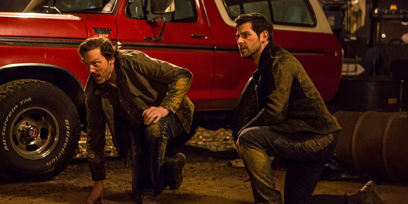 Nick Burkhardt (David Giuntoli) and Monroe (Silas Weir Mitchell) crouch by a red truck at night in 'Grimm' Season 3, Episode 13 "Revelation" (2013).