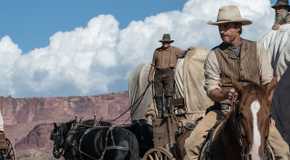 Luke Wilson as Van Weydan riding on a horse next to a wagon train in Horizon: An American Saga