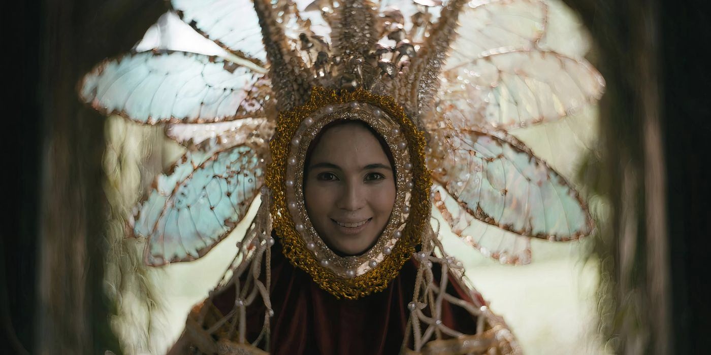 A young woman in an elaborate costume smiling in in In My Mother's Skin