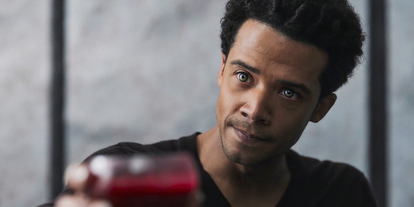 A close-up of Louis (Jacob Anderson) looking slightly off-screen to the left and raising a glass of blood in Interview with the Vampire