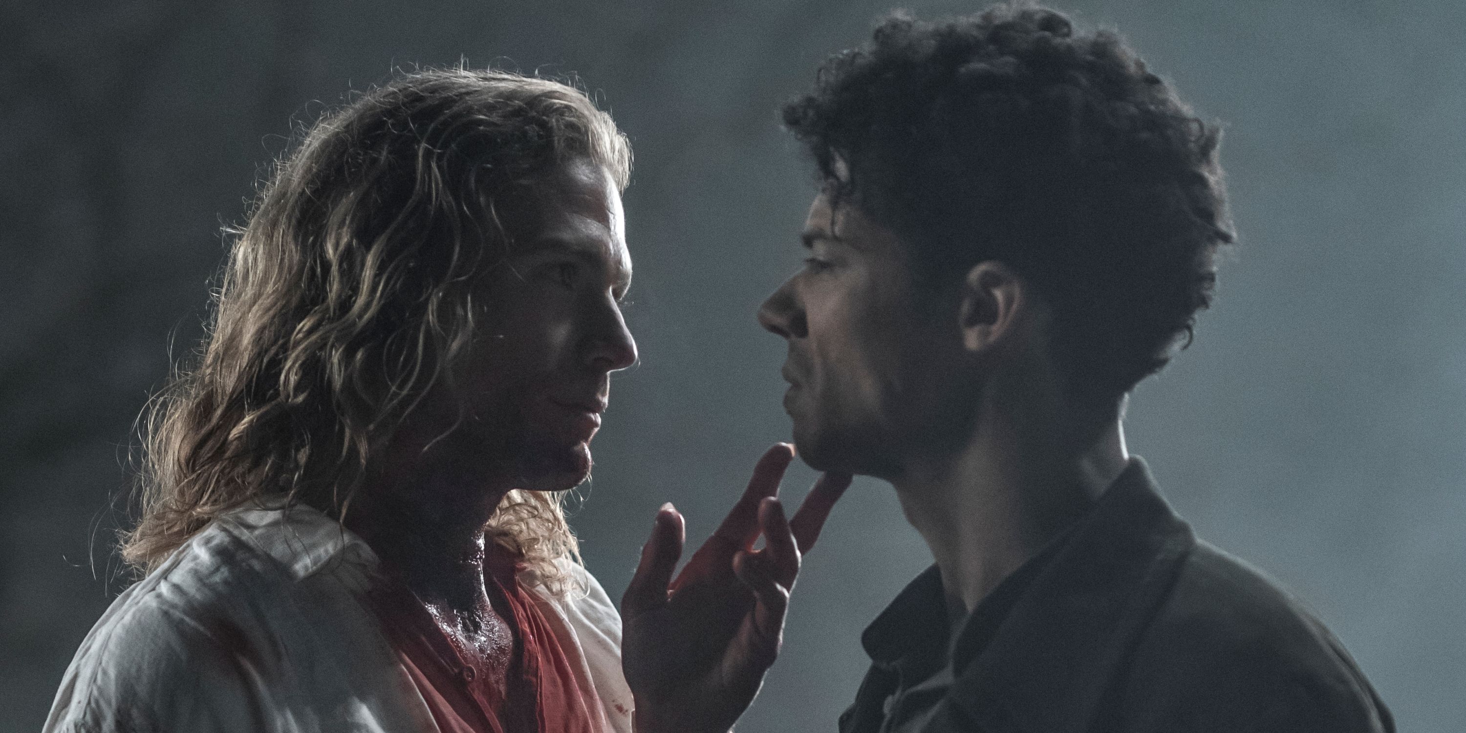 Jacob Anderson as Louis and Sam Reid as Lestat holding their chins with a bloody shirt in Interview with the Vampire