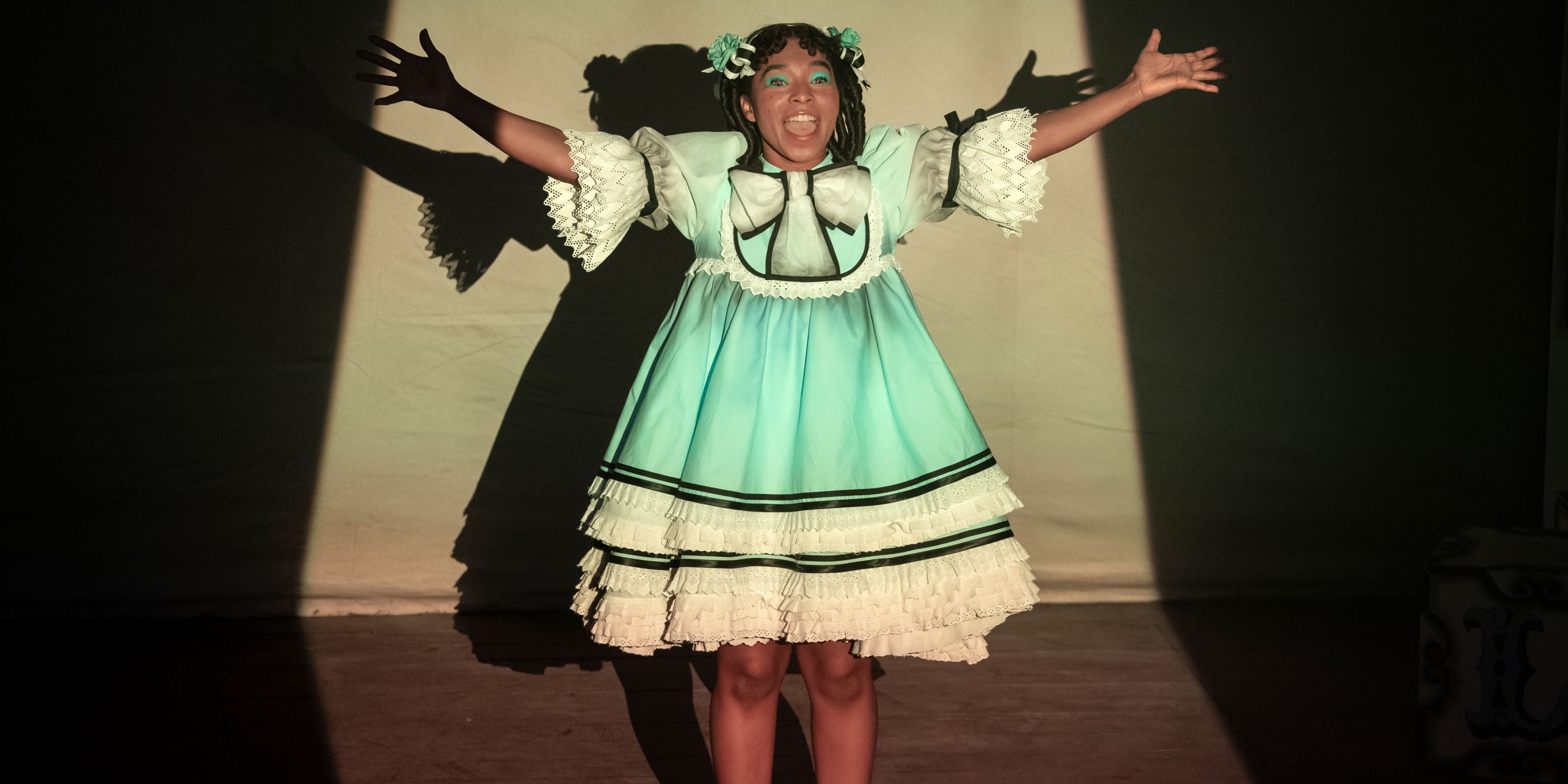 Delainey Hayles as Claudia performing onstage in a blue & white ruffle dress in Interview with the Vampire