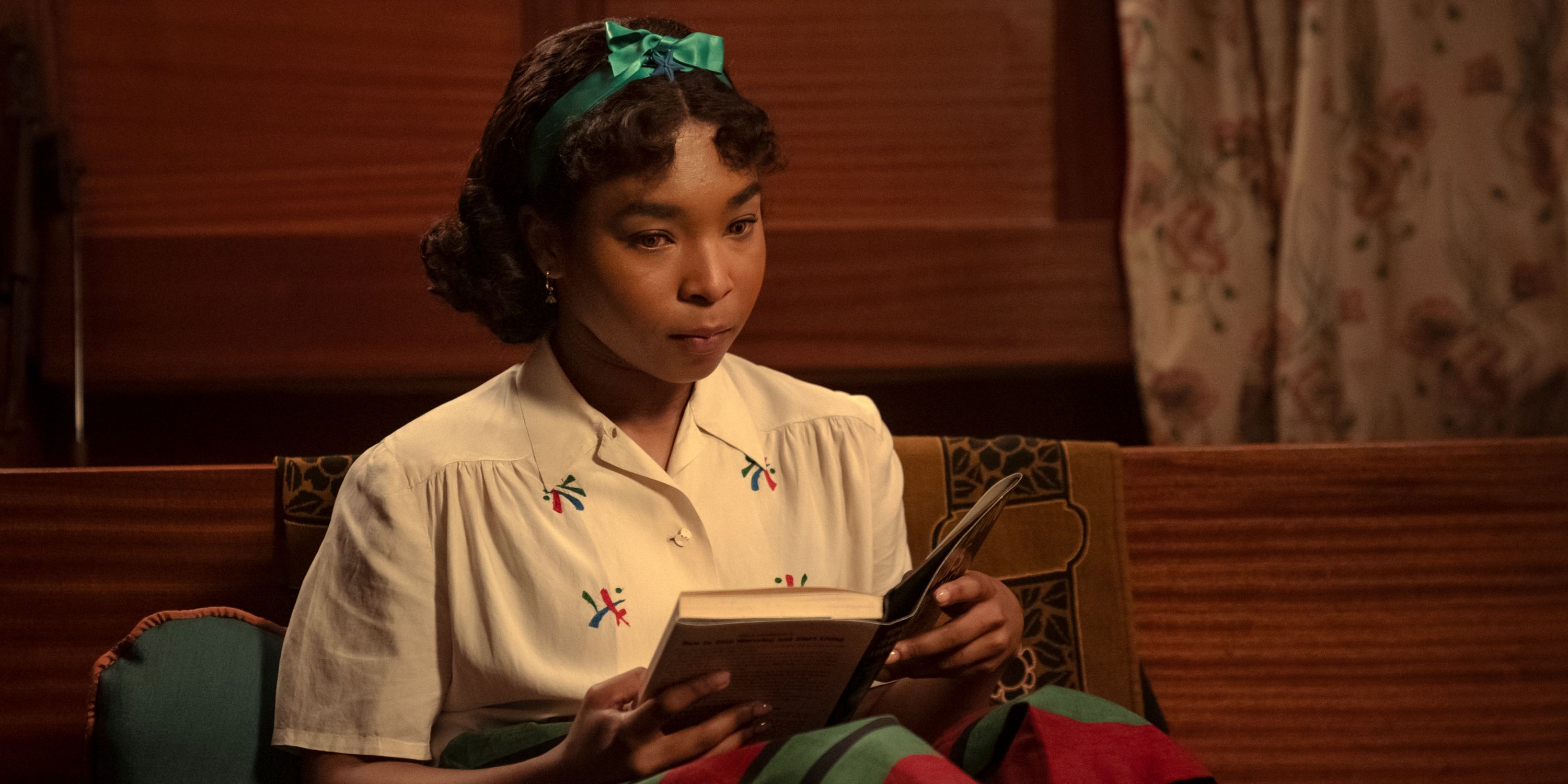 Delainey Hayles as Claudia reading a book with a green bow in her hair in Interview with the Vampire