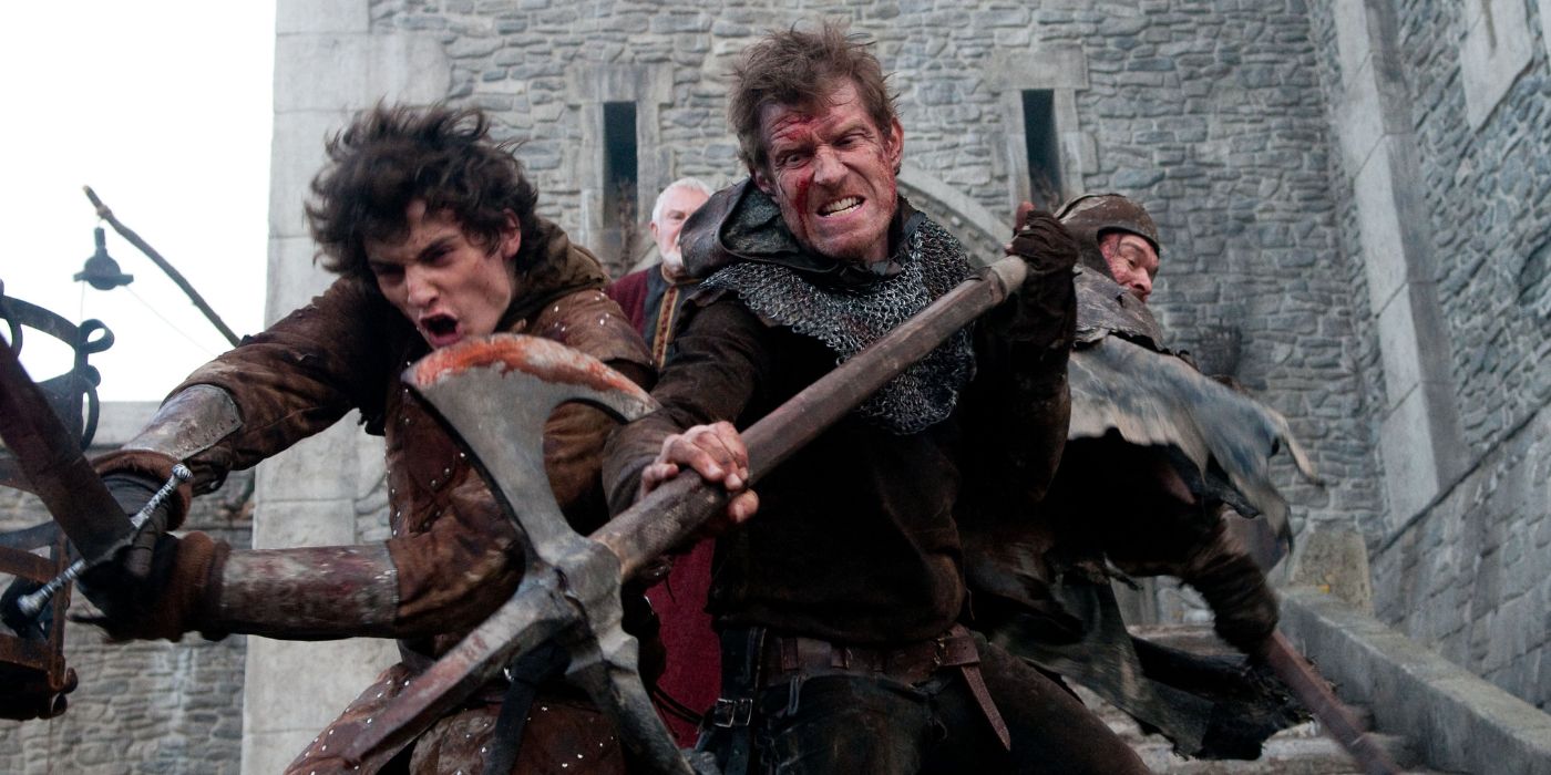 Warriors hold off attackers as they back up towards a building with bloodied weapons in &lsquo;Ironclad&rsquo; (2011).