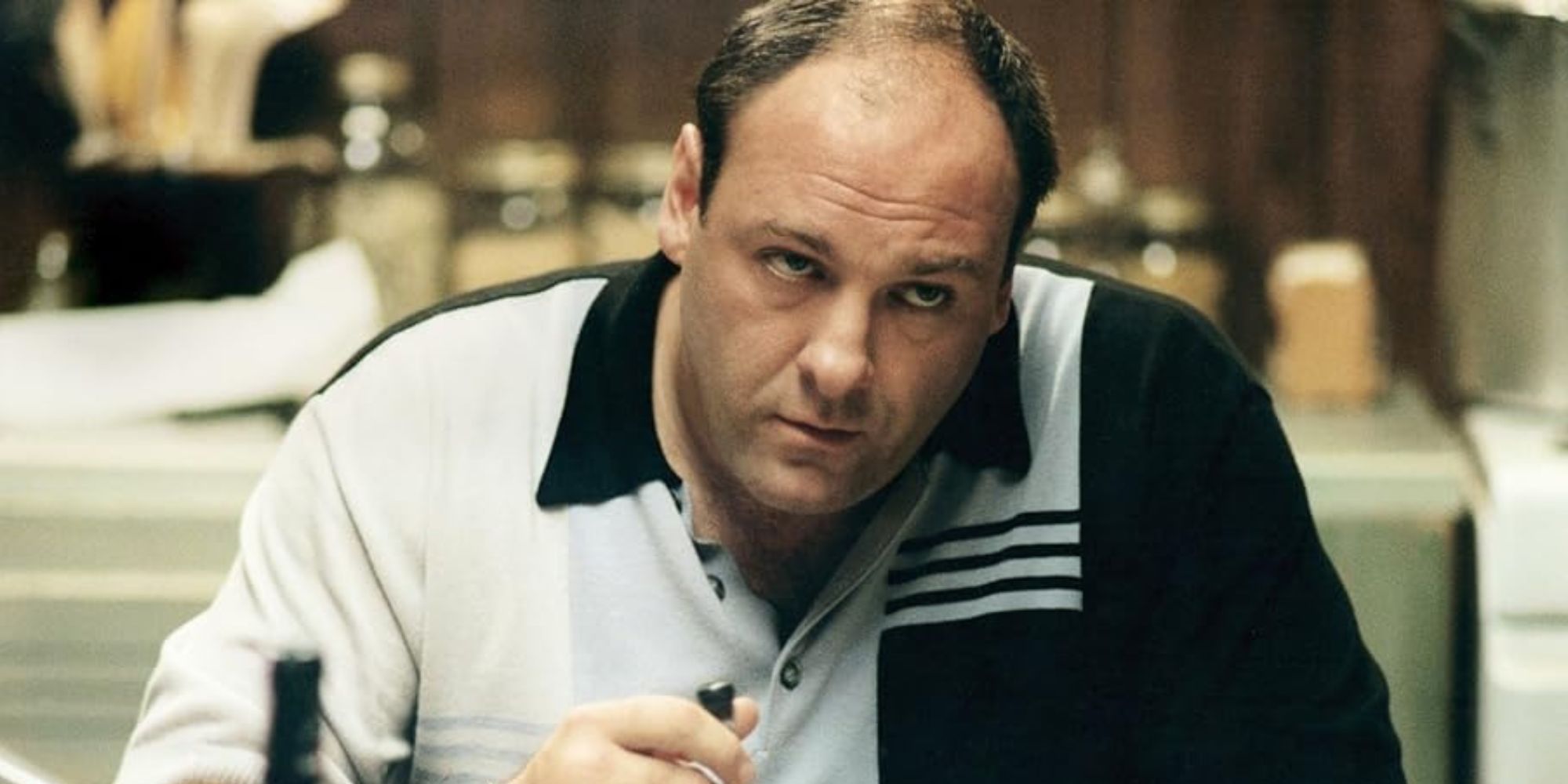 James Gandolfini sitting at a table eating in The Sopranos