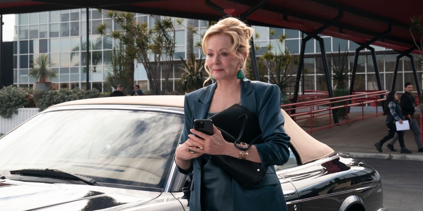 Jean Smart holding her phone and purse standing next to her car in Hacks Season 3