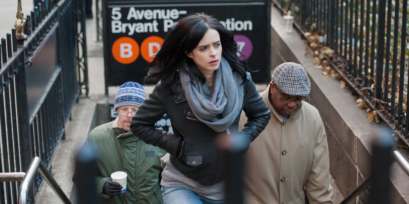 Jessica Jones (Krysten Ritter) emerging from a crowded underground subway stairway with her hands in her leather jacket pockets and and looking to the left