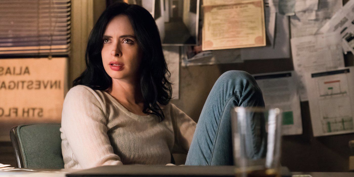 Jessica Jones (Krysten Ritter) sitting behind her desk and staring dryly ahead at someone offscreen and slightly to the left