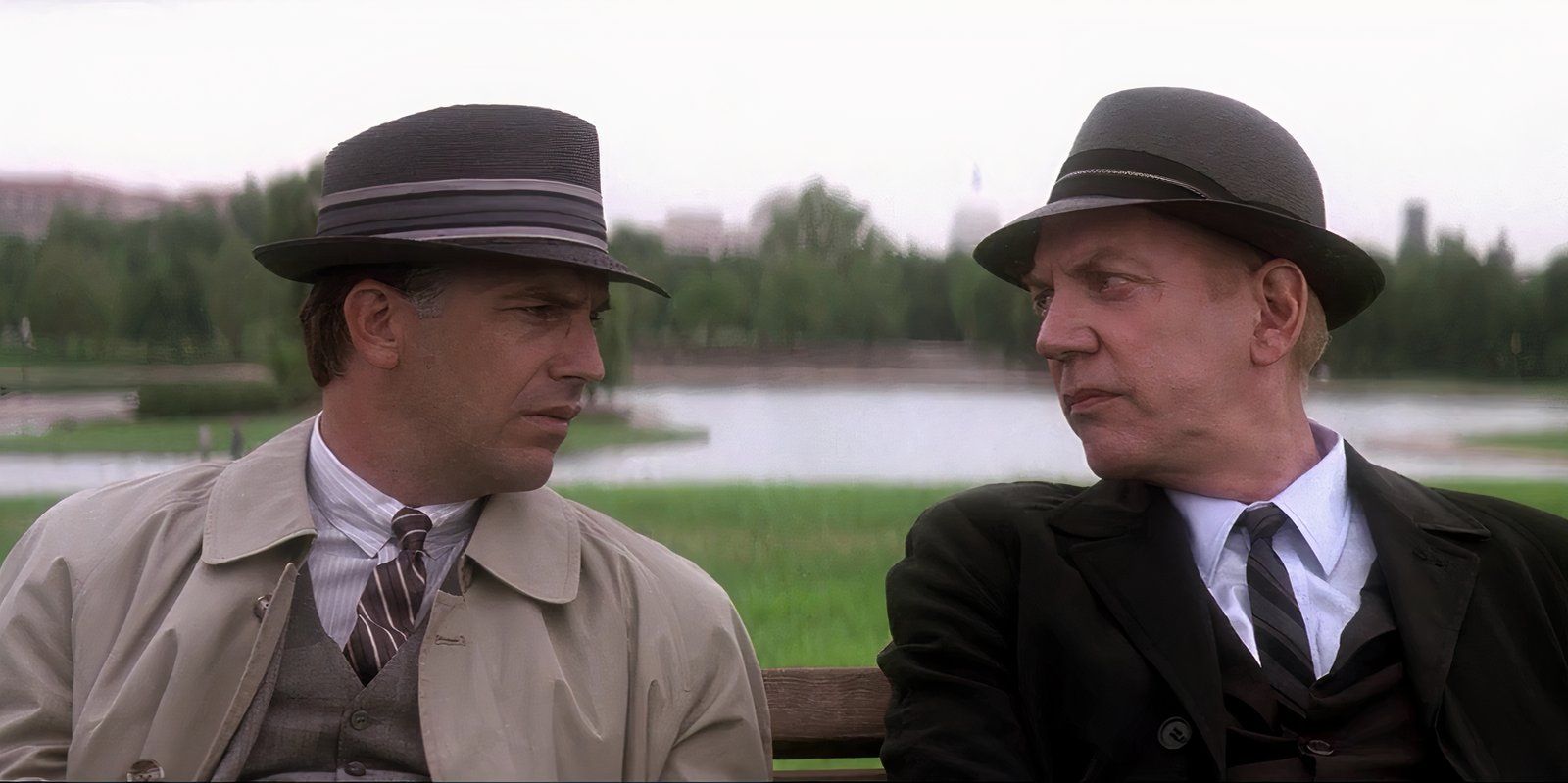 Donald Sutherland y Kevin Costner sentados en un banco de un parque en Washington en el JFK de Oliver Stone.