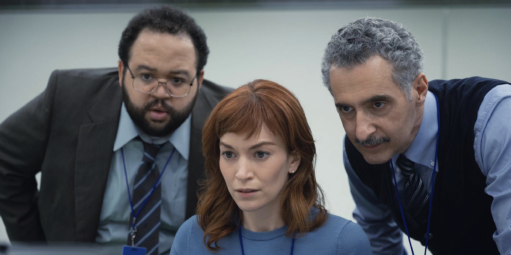 John Turturro, Britt Lower, and Zach Cherry in Severance Half Loop looking at a computer.