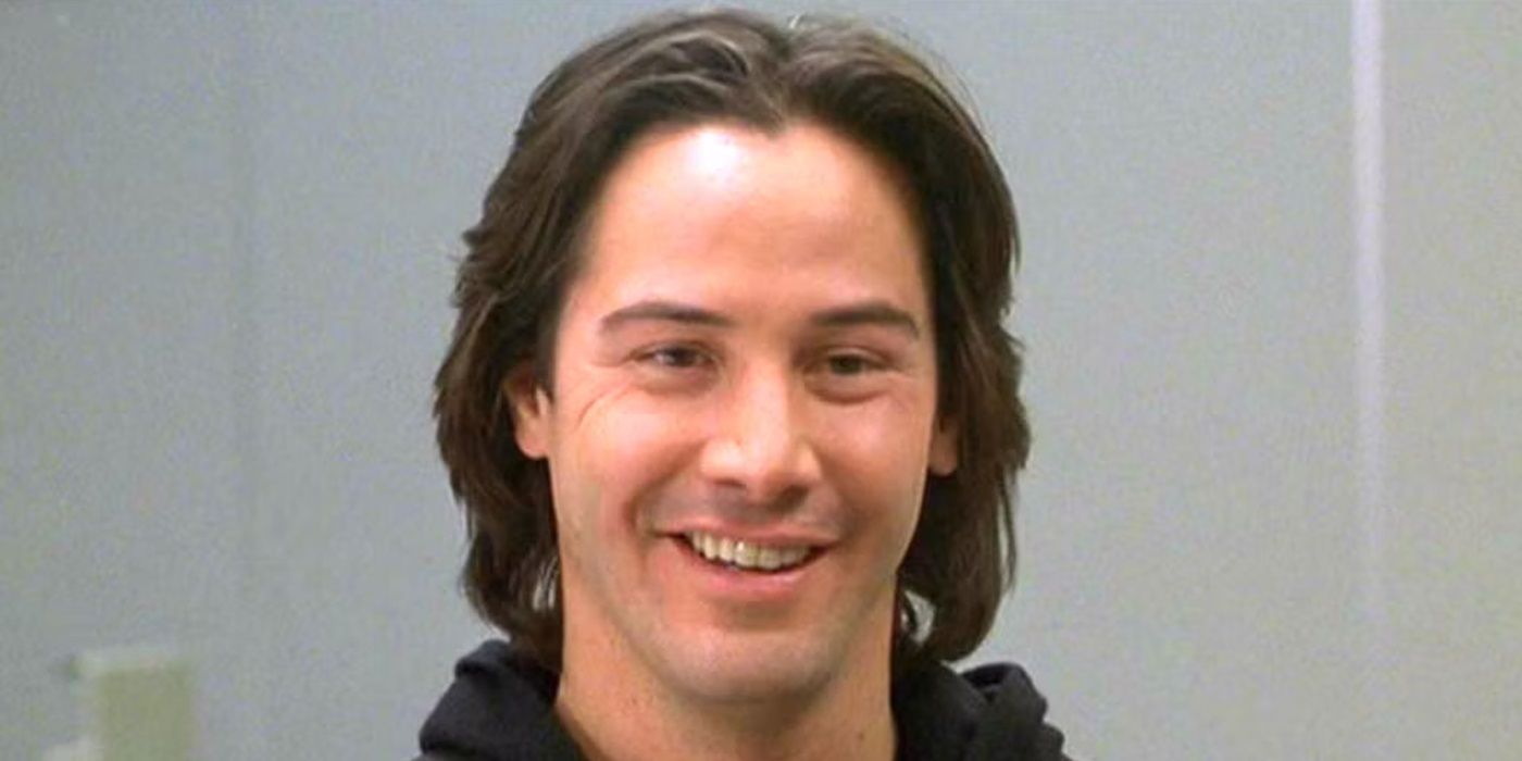 Keanu Reeves as David Allen Griffin smiling at a person offscreen in The Watcher (2000)