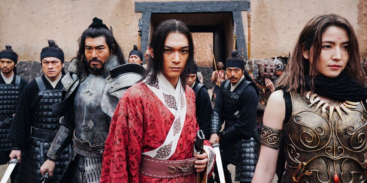 The cast of 'Kingdom' (2019), with Xin in the centre, looking menacing and bearing weapons in front of a castle wall