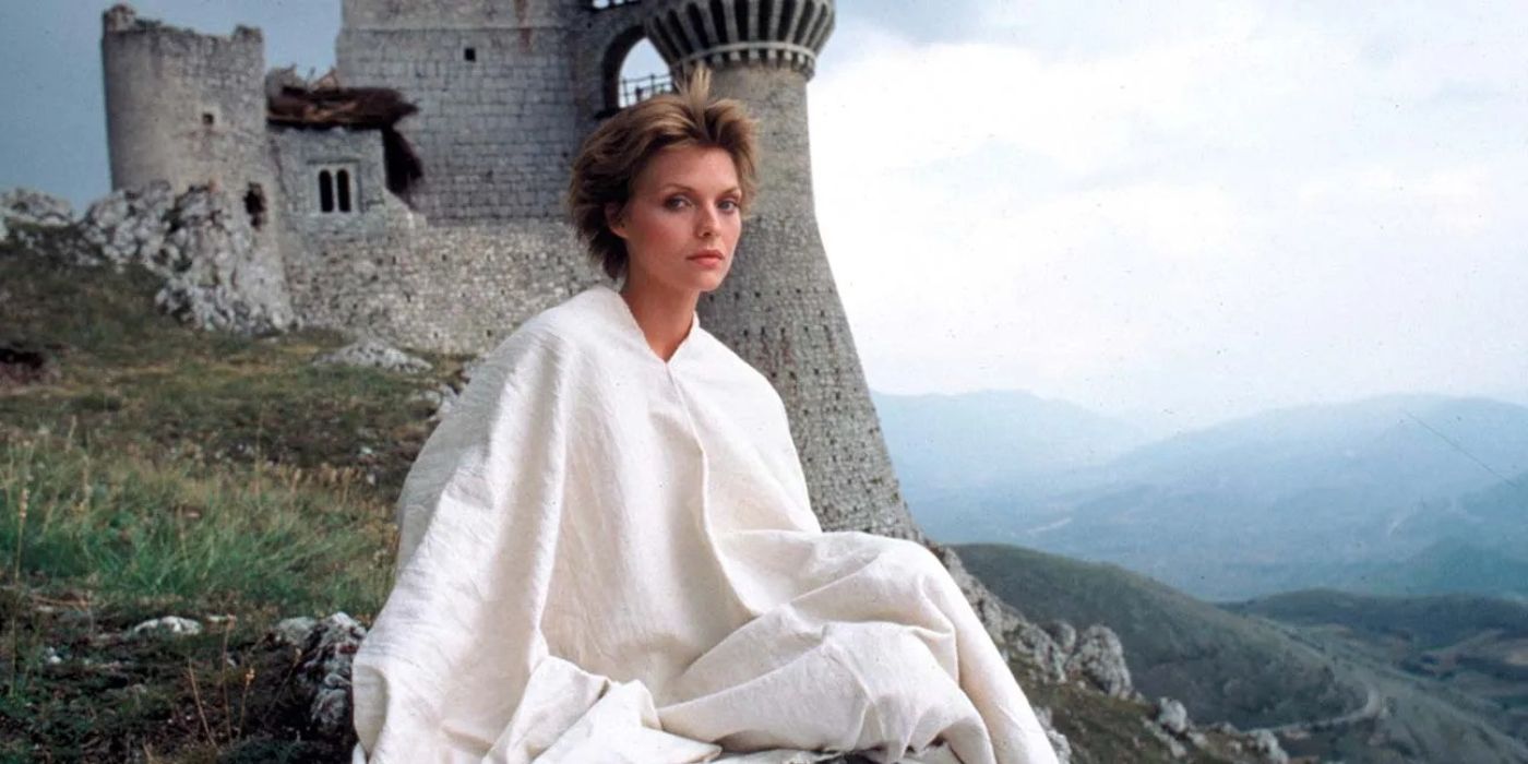 Iseabeu of Anjou sitting on the grass with a castle in the background in Ladyhawke