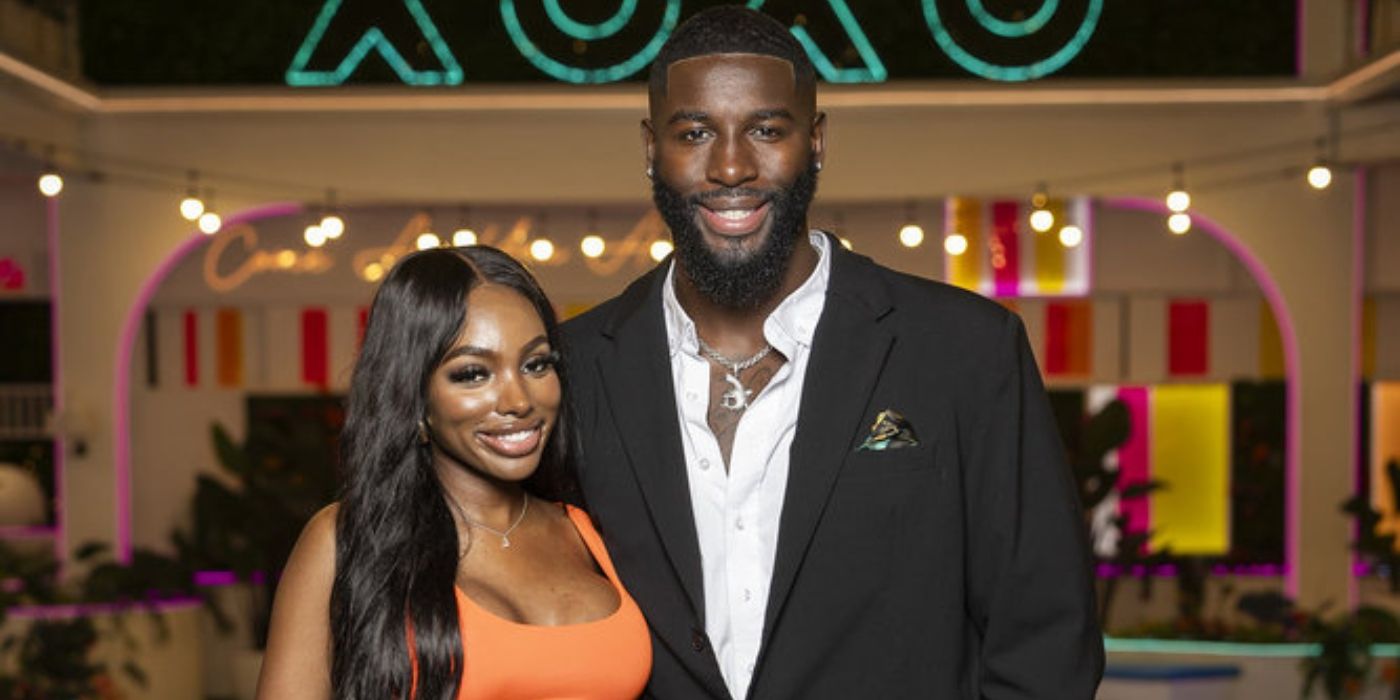 JaNa Craig wears an orange dress and stands next to Coye Simmons in a suit on “Love Island USA”