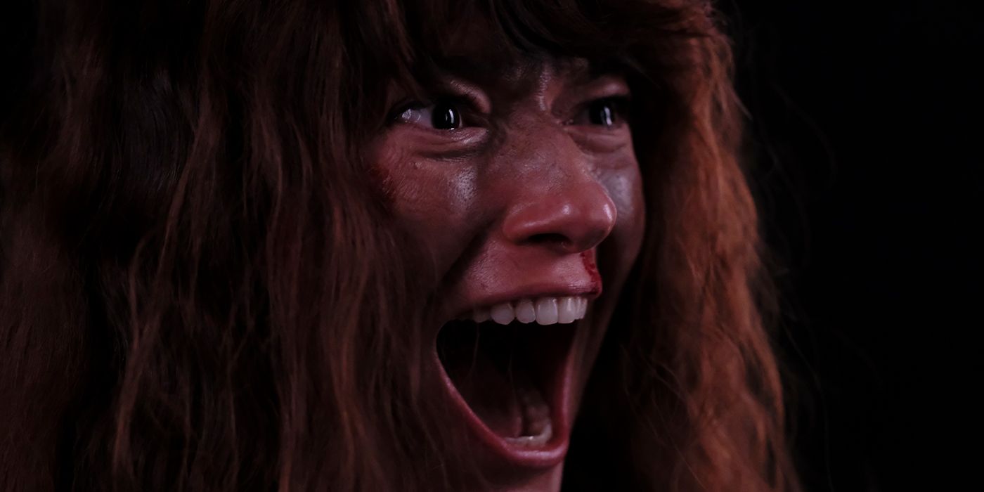 Close up of Andrea Tivadar as Delilah, covered in blood and screaming in Lumina