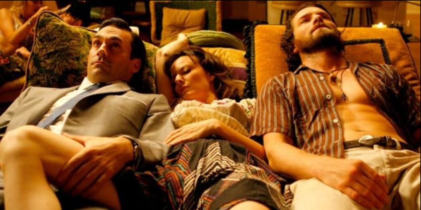 Don Draper (Jon Hamm) sits on the couch with stoned beatniks in &lsquo;Mad Men&rsquo; Season 1, Episode 8 &ldquo;The Hobo Code&rdquo; (2007).