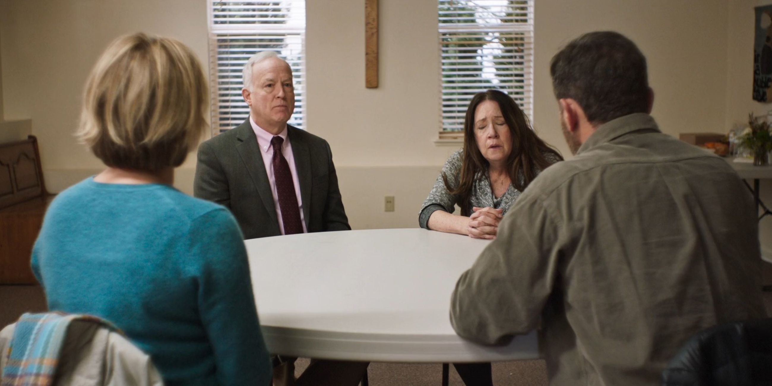 Four parents sitting around a table and having a tense discussion in Mass (2021)