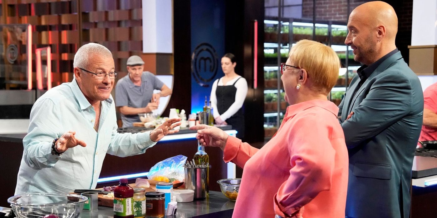 One of the Baby Boomer contestants cooking with judges Joe and Lidia Bastianich watching in a scene from Season 14 of 'MasterChef.'