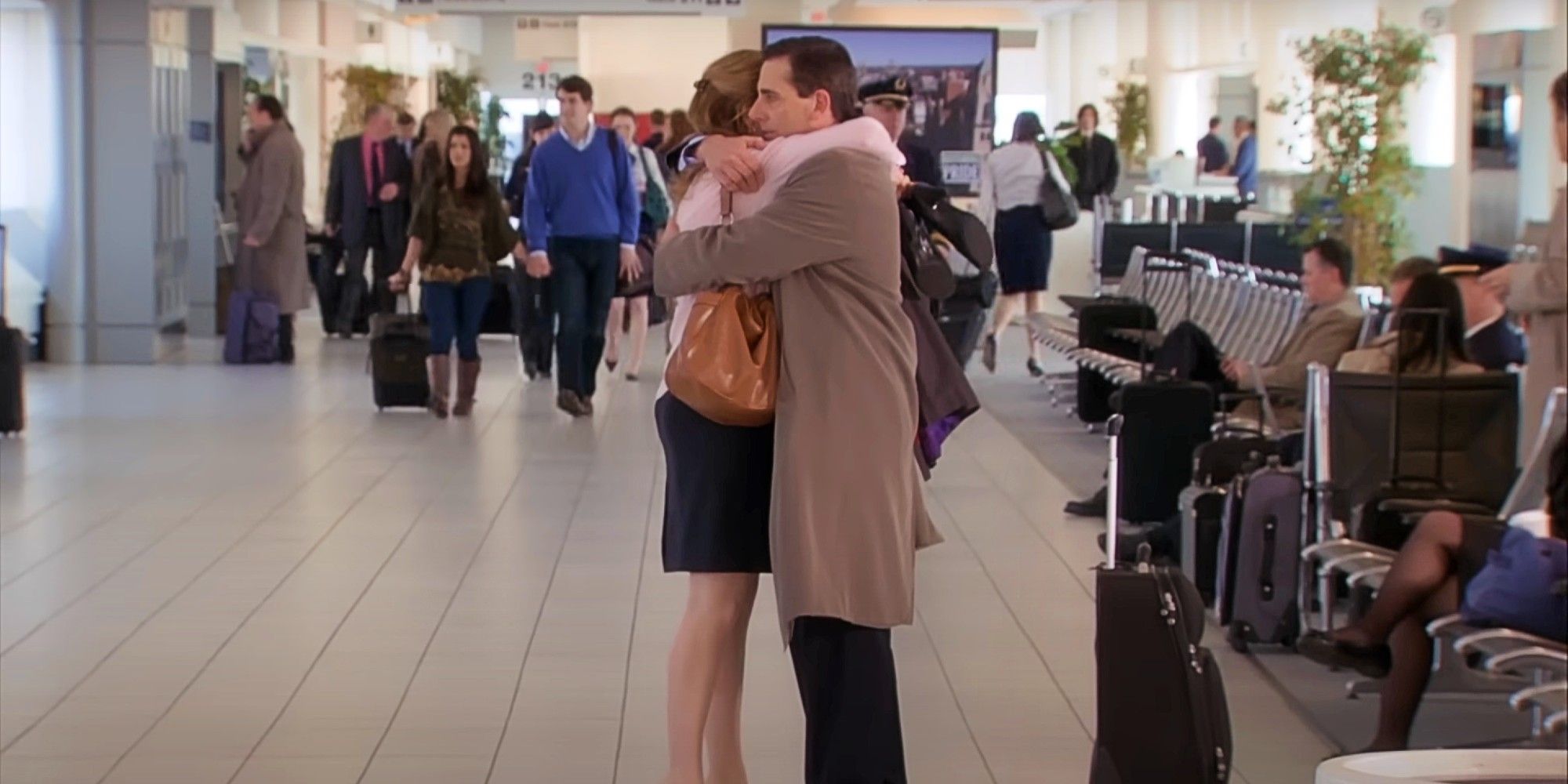 ​​​​​​​Pam (Jenna Fischer) and Michael (Steve Carell) hugging goodbye at an airport in The Office