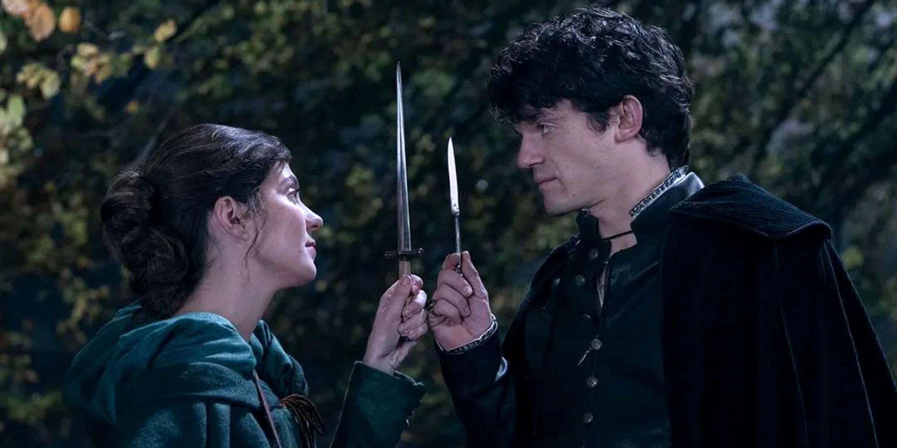 Emily Bader and Edward Bluemel comparing the size of their knives in the forest in My Lady Jane