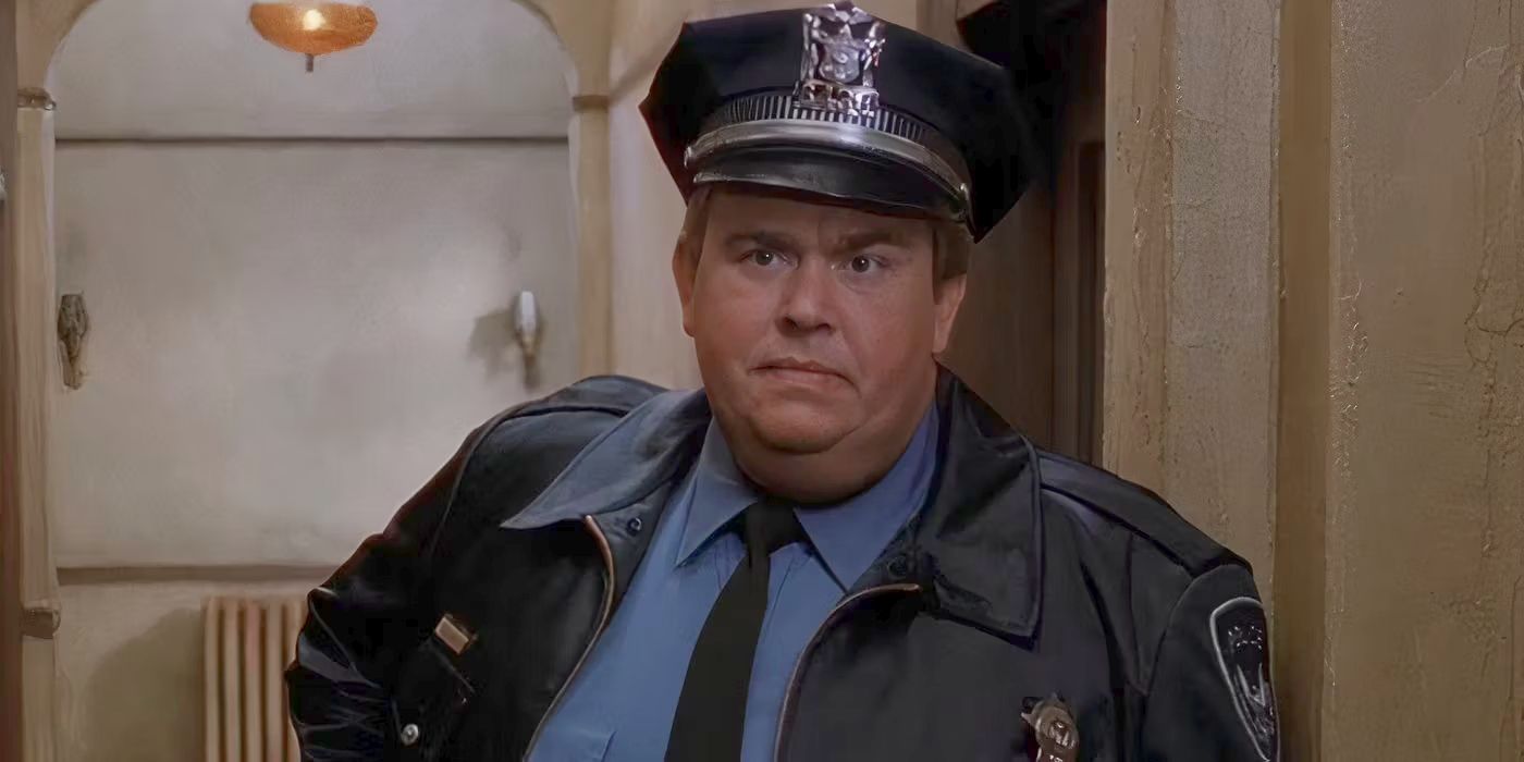 John Candy as Danny Muldoon, wearing a cop uniform and standing in a hallway, looking serious in Only the Lonely