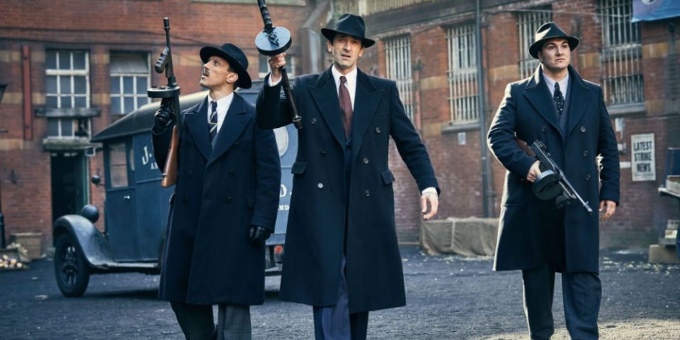 Luca Changretta (Adrien Brody) and two of his goons march through the streets of Birmingham wielding machine guns in 'Peaky Blinders' Season 4, Episode 5 "The Duel" (2017).