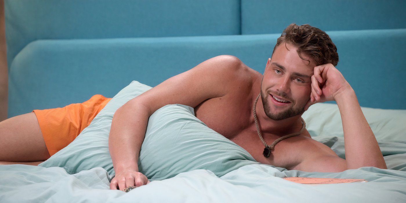 Harry Jowsey lies in a bed with blue sheets on 'Perfect Match' Season 2