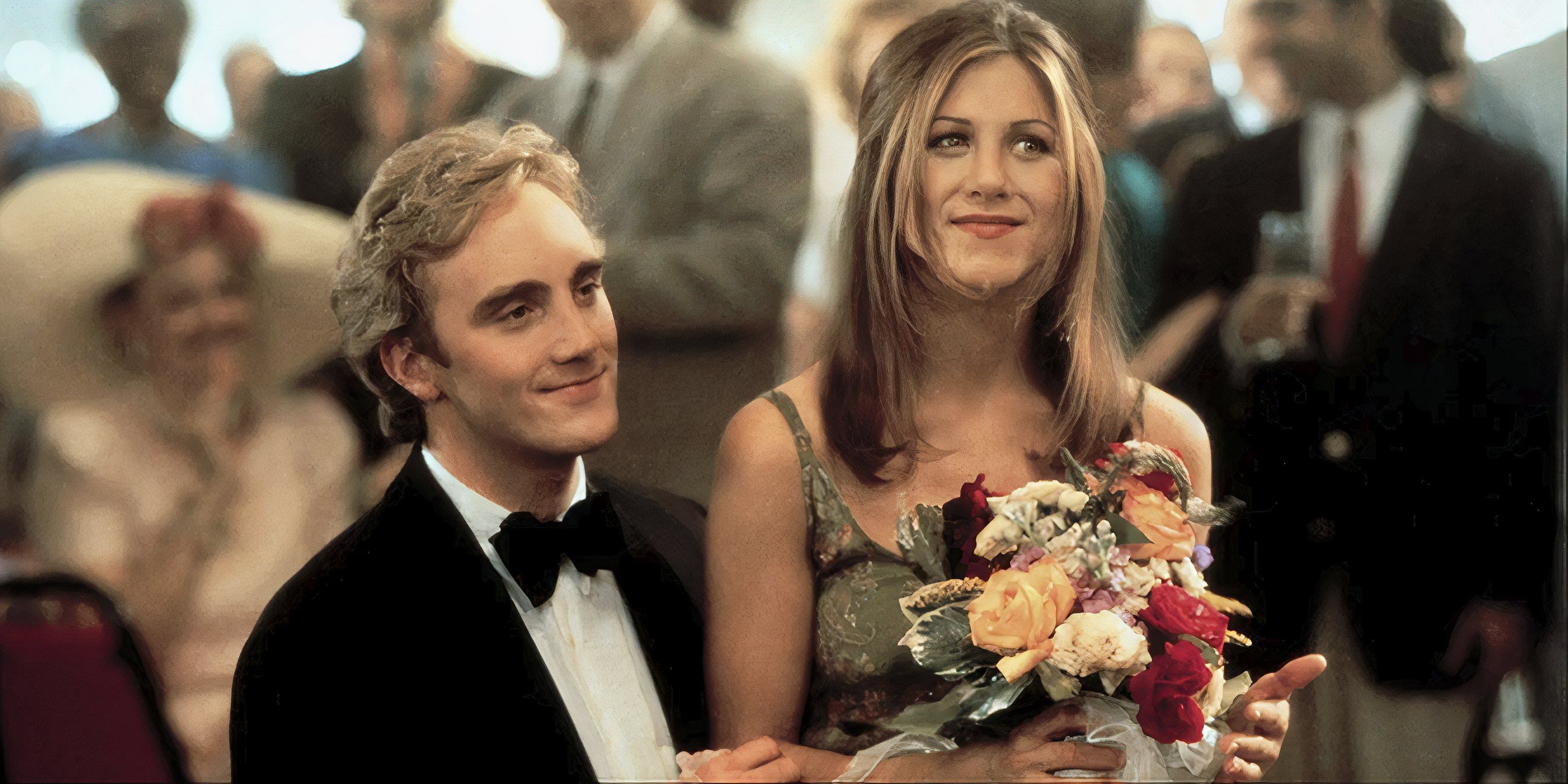 Jennifer Aniston sitting on Jay Mohr&rsquo;s lap at a wedding in Picture Perfect