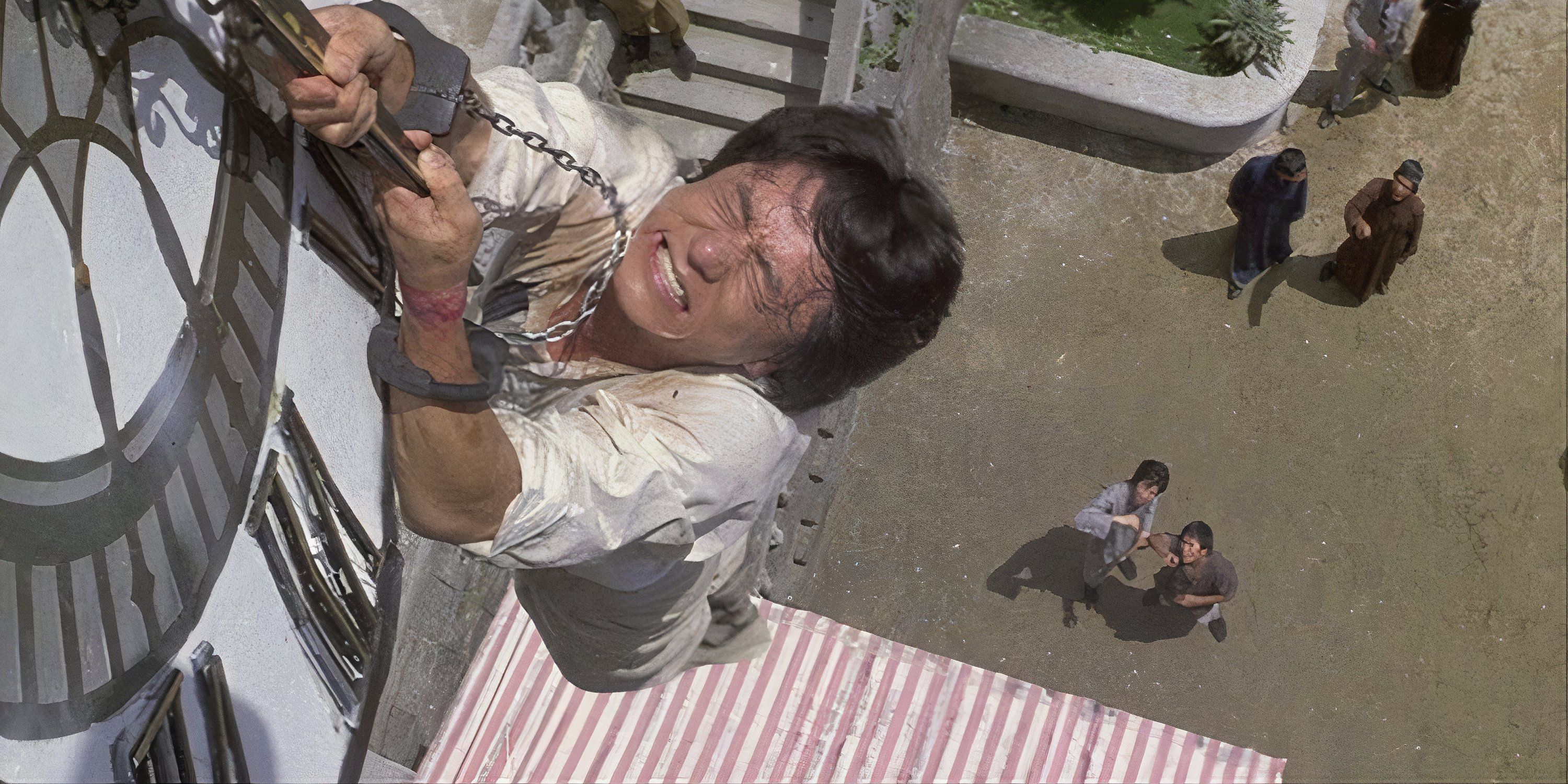 Jackie Chan holding on to a large clock hand, dangling over a street in Project A