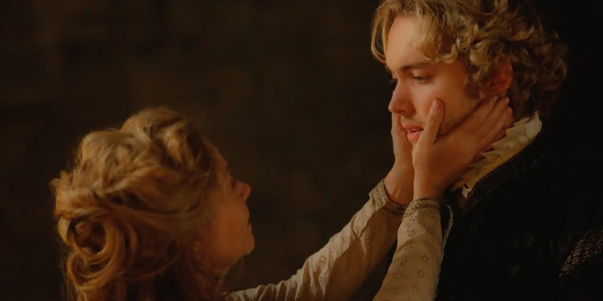 Queen Catherine softly holding Francis' face in her hands as they face one another